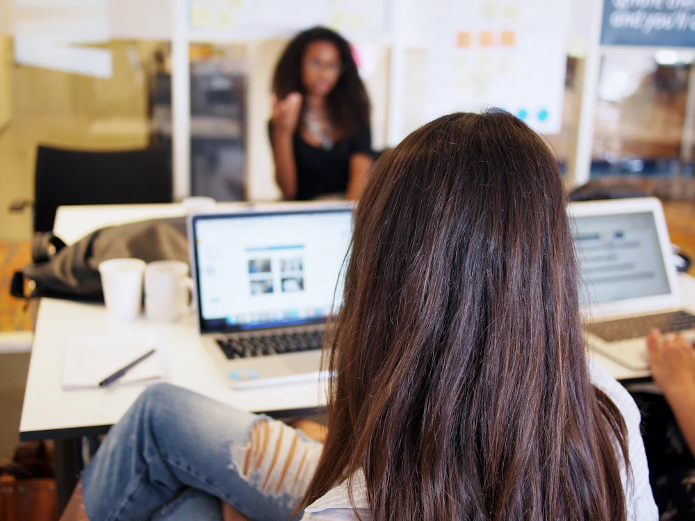 Business owner reviewing her work on a laptop in a shared workplace